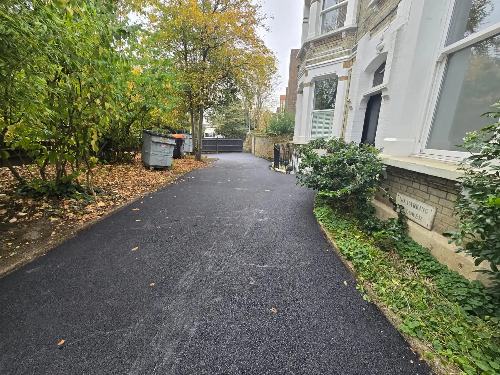 Paved street between houses with fall foliage and a driveway under construction.
2. Concrete Driveways.