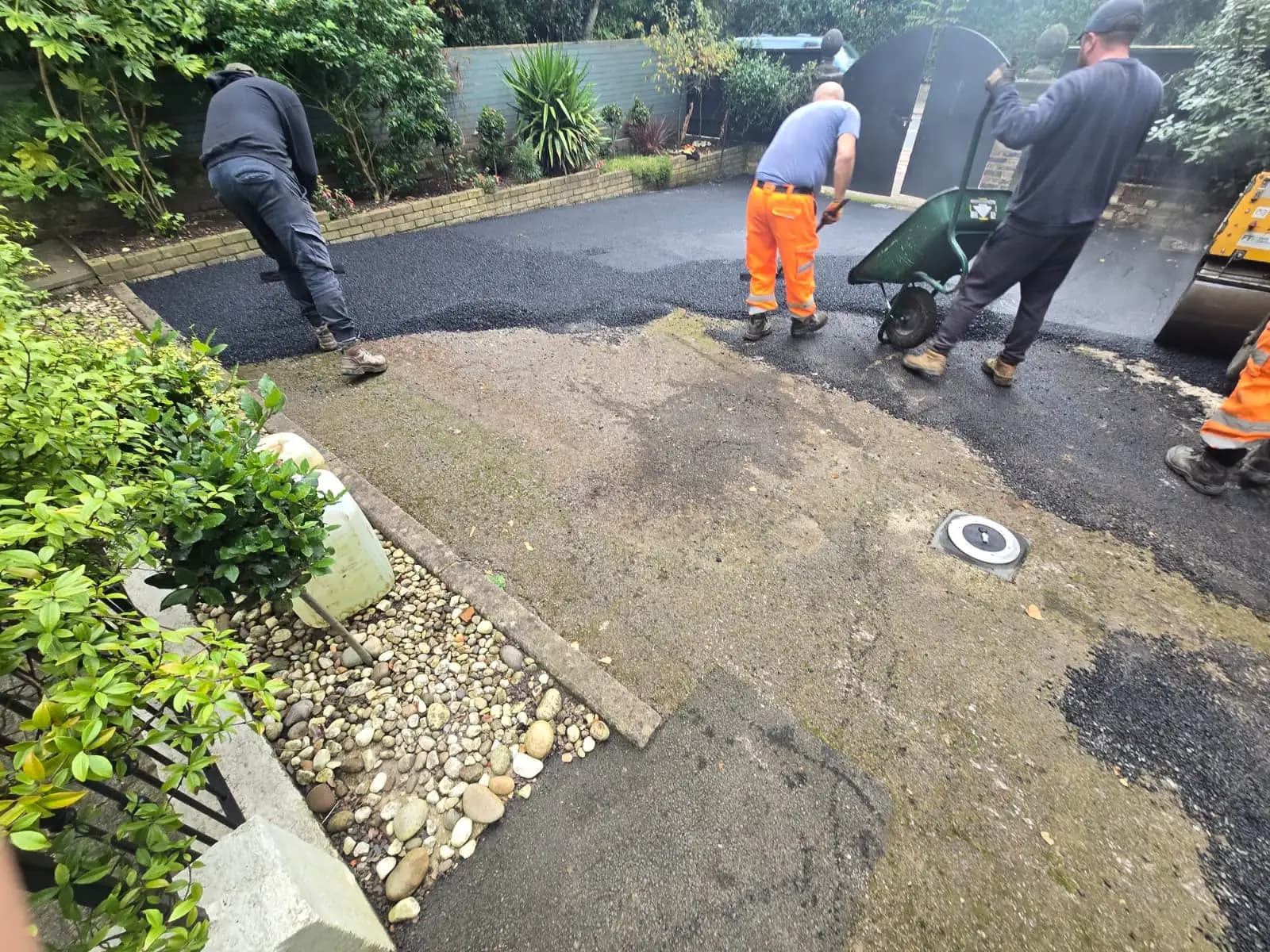 Workers in orange safety suits paving driveway with shovels.
2. Concrete Driveways - suggests outdoor home...