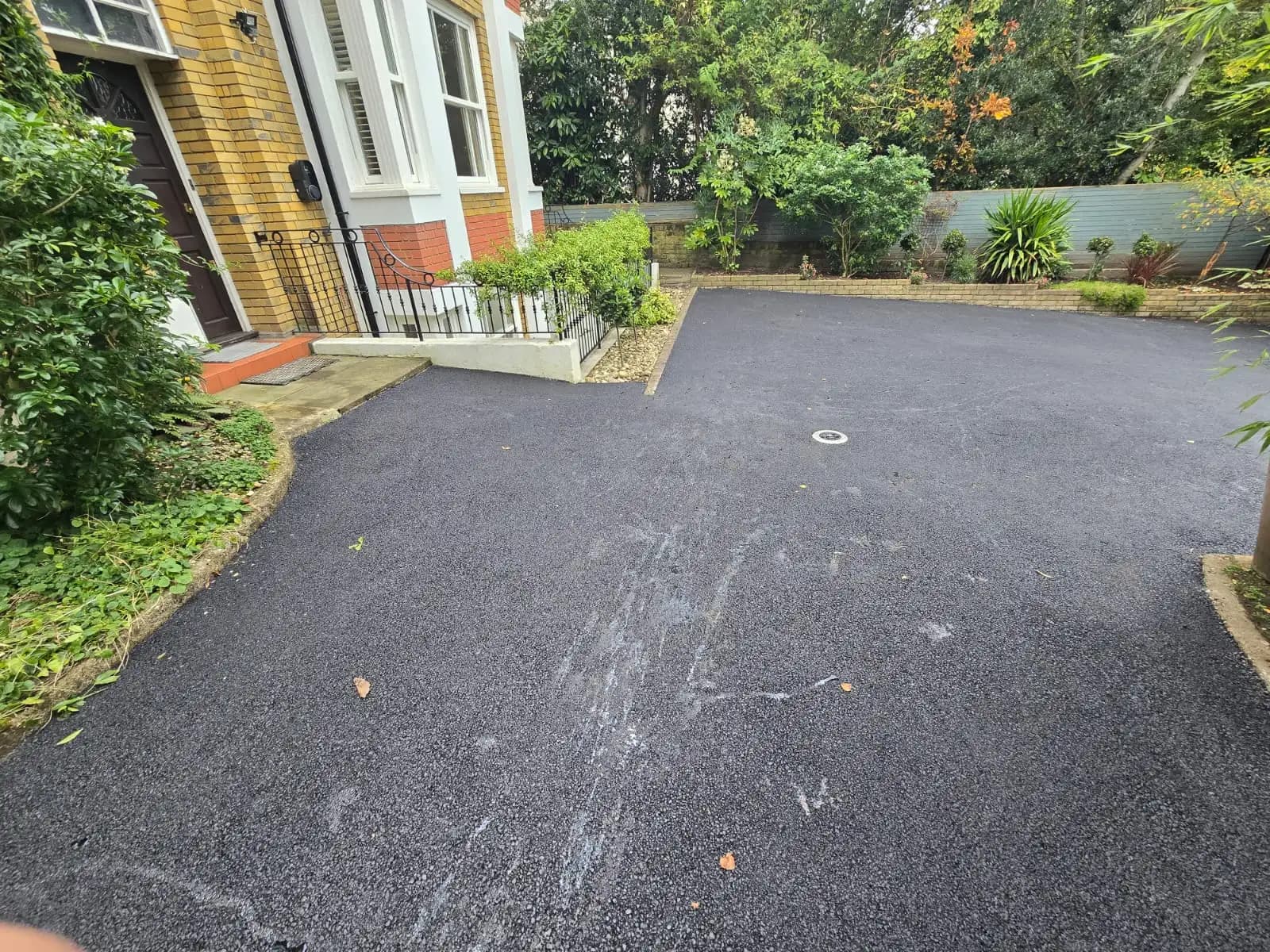 This image shows a driveway under construction with gravel spread across it. It is not yet complete or paved. There...