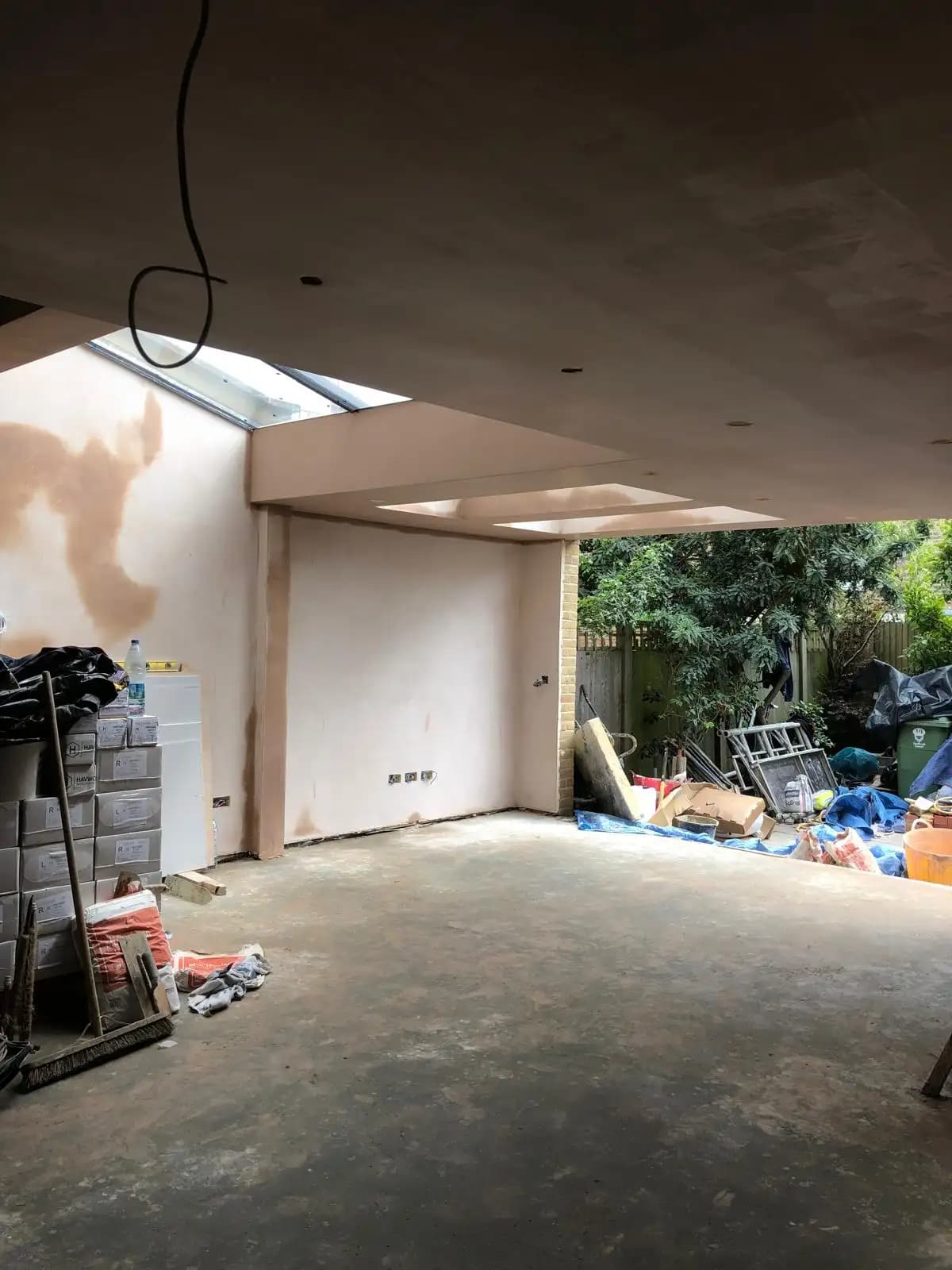 Abandoned room with exposed ceiling, under construction with tools and materials scattered about, suggesting home...